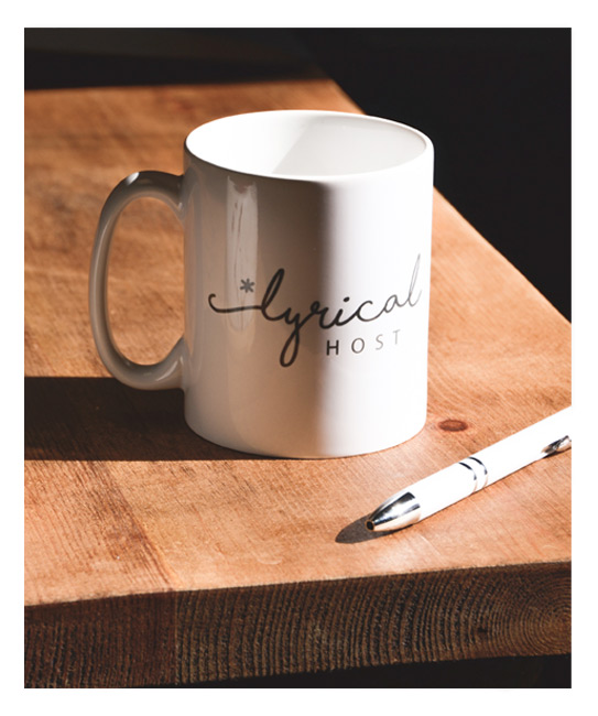 Lyrical Host mug and pen on wooden desk