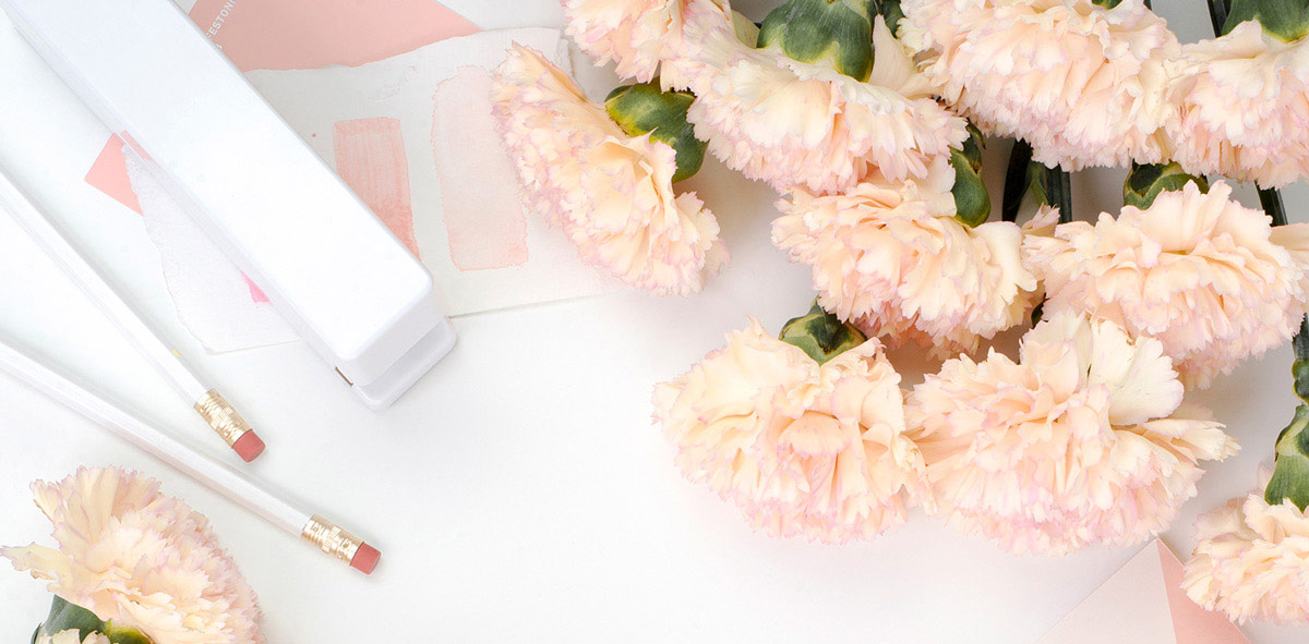 White desktop with flowers and stationery