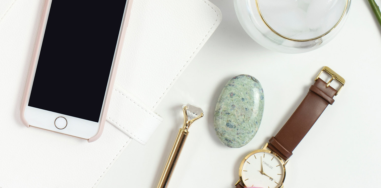 I-phone, watch and facial tools on a white background