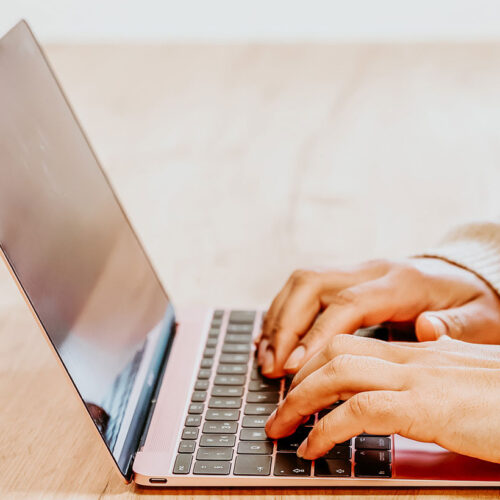 Sabrina typing at laptop on desk
